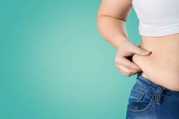 Image of woman pinching her love handles to show weight gain Woburn Sands